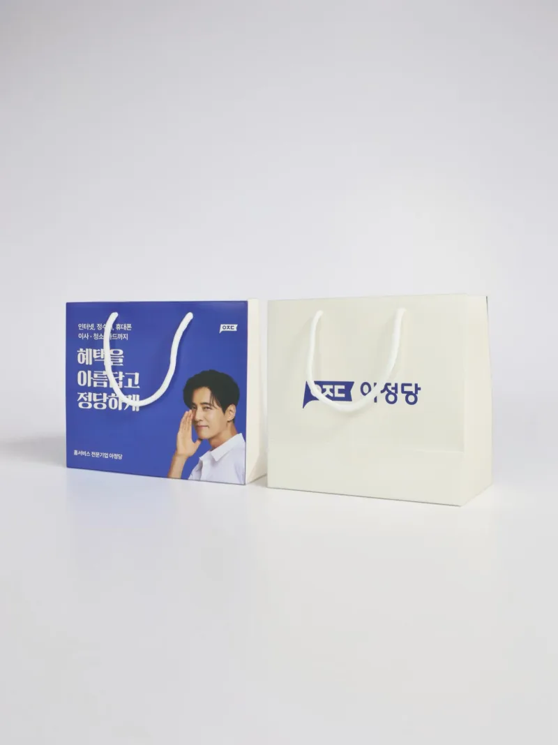 전면 그래픽과 브랜드 로고를 담은 아정당 맞춤 쇼핑백