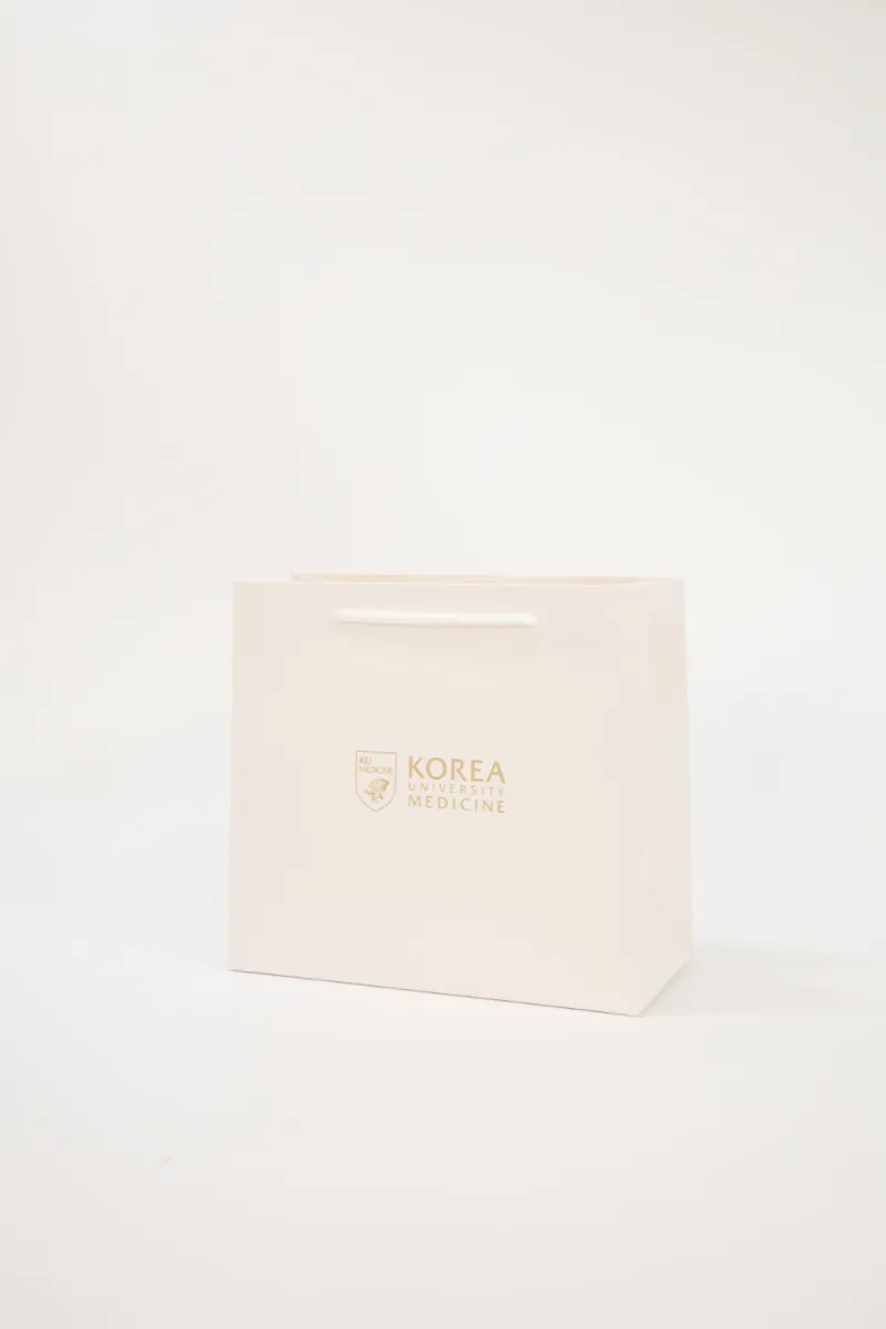 화이트 바탕에 라이트골드 로고를 담은 고려대학교 구로병원 쇼핑백